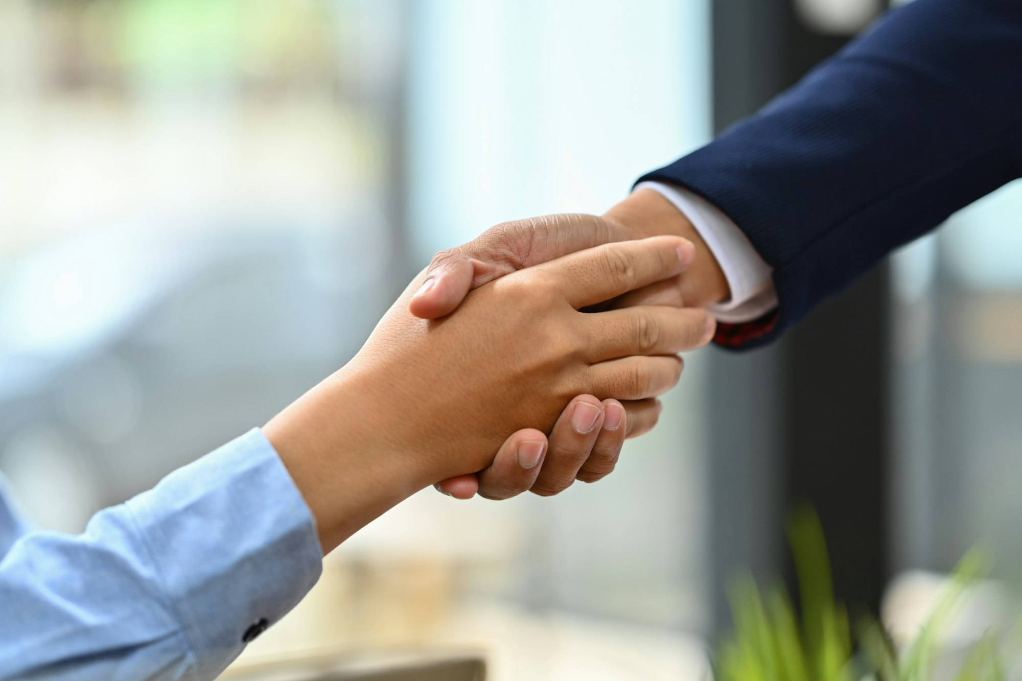 Successful businesspeople shaking hands closing deal or making agreement.