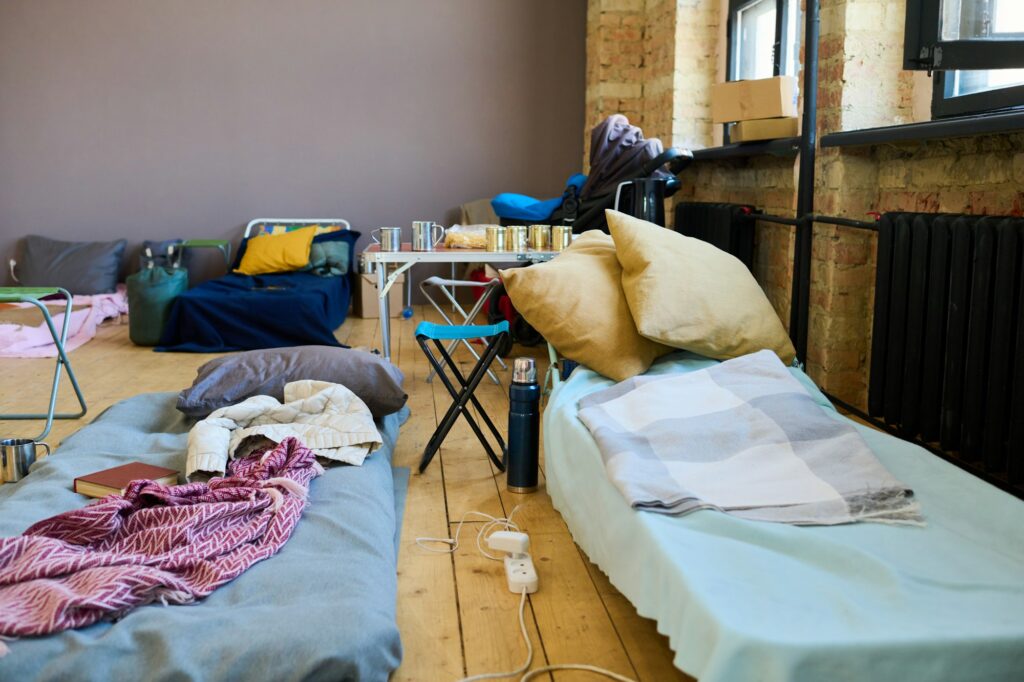 Two sleeping places of refugees with mattresses done with blankets or plaids